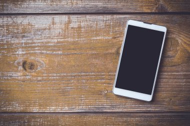 Eski bir ahşap zemin üzerine modern akıllı telefon. Yakın çekim