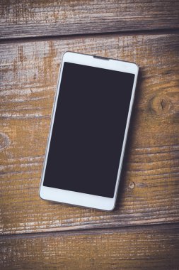 Eski bir ahşap zemin üzerine modern akıllı telefon. Yakın çekim