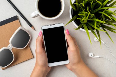 Gri taş masa üzerinde bir akıllı telefon kullanan kadın. Yakın çekim
