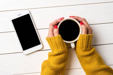 Sıcak kazaklı kahve tutan eller