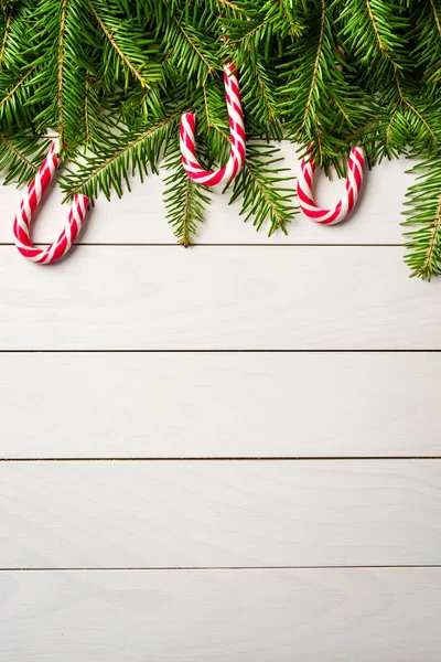 Christmas background with candy canes on white wooden table