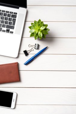 Beyaz ahşap ofis masaüstü ile laptop ve iş malzemeleri