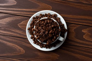 İçinde beyaz kahve fincanı kavrulmuş kahve çekirdekleri. Yakın çekim