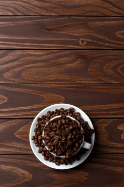 İçinde beyaz kahve fincanı kavrulmuş kahve çekirdekleri. Yakın çekim