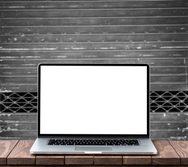 Eski metal arka plan karşı ahşap masa boş beyaz ekran ile modern dizüstü bilgisayar