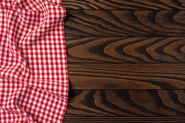 Eski bir ahşap masa üzerinde kırmızı kareli masa örtüsü. Yakın çekim