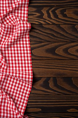 Eski bir ahşap masa üzerinde kırmızı kareli masa örtüsü. Yakın çekim