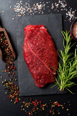 Ham sığır eti biftek karanlık beton masada. Üstten görünüm