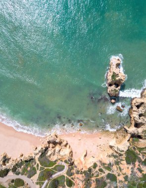Tropikal kumlu plaj, uçurumlar ve okyanus havadan görünümü.