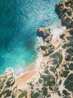 Tropikal kumlu plaj, uçurumlar ve okyanus havadan görünümü.