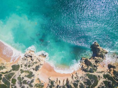 Tropikal kumlu plaj, uçurumlar ve okyanus havadan görünümü.
