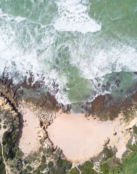 Tropikal kumlu plaj, uçurumlar ve okyanus havadan görünümü.