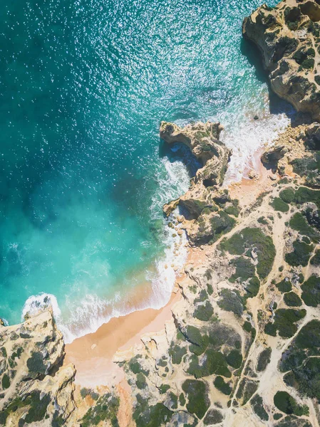 Tropikal kumlu plaj, uçurumlar ve okyanus havadan görünümü.