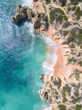 Tropikal kumlu plaj ve okyanus turkuaz su ile havadan görünümü.
