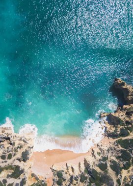 Tropikal kumlu plaj ve okyanus turkuaz su ile havadan görünümü.
