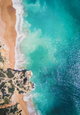 Tropikal kumlu plaj ve okyanus turkuaz su ile havadan görünümü.