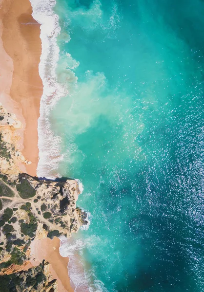 Tropikal kumlu plaj ve okyanus turkuaz su ile havadan görünümü.