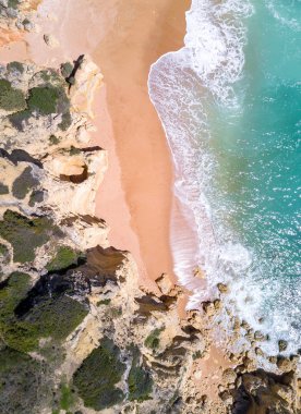 Tropikal kumlu plaj ve okyanus turkuaz su ile havadan görünümü.