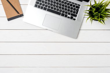 Beyaz ahşap ofis masaüstü laptop ve iş malzemeleri ile. Üstten görünüm