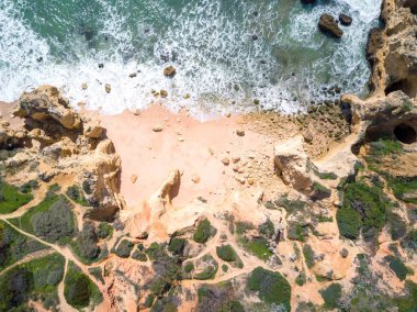 Tropikal kumlu plaj ve okyanus turkuaz su ile havadan görünümü.