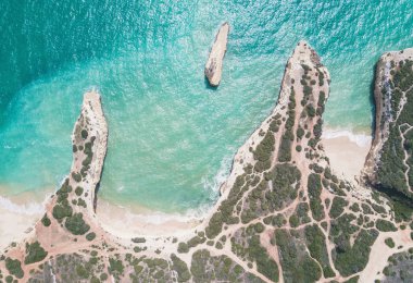 Tropikal kumlu plaj ve okyanus turkuaz su ile havadan görünümü.