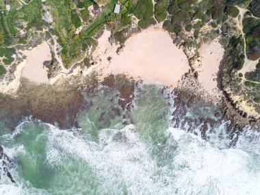 Tropikal kumlu plaj ve okyanus turkuaz su ile havadan görünümü.