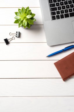 Beyaz ahşap ofis masaüstü ile laptop ve iş malzemeleri.