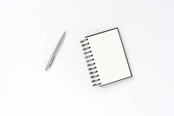 Notepad with pen on white background