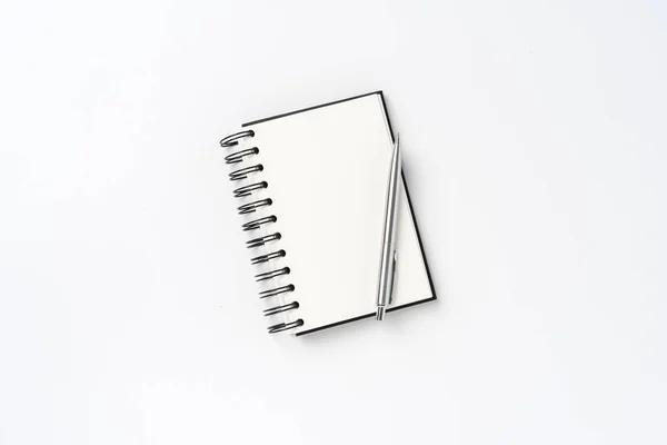 Notepad with pen on white background