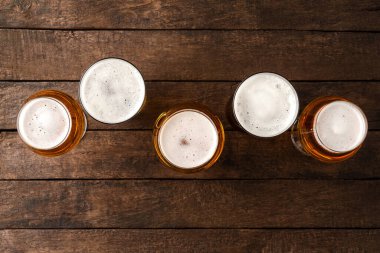 Kopyalama alanı olan ahşap masada bira bardakları.