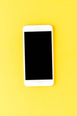 Sarı masaüstünde boş ekran olan akıllı telefon. Üst görünüm