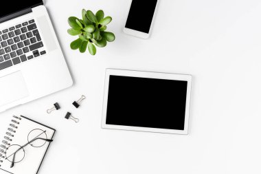 Ticari aksesuarları ve boş ekranlı dijital tableti olan şık bir ofis masası. Modern işyeri. Üst görünüm