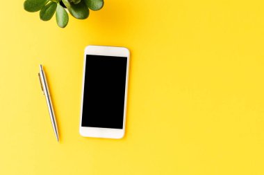 İş geçmişi, cep telefonu ve sarı masadaki boş ekran. Aksesuarlı ofis masaüstü
