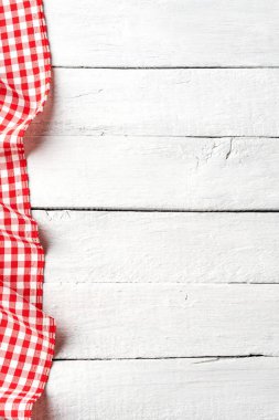 Kopyalama alanı olan beyaz eski tahta masa üzerindeki kırmızı kareli masa örtüsü