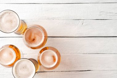 Kopyalama alanı olan eski ahşap arka planda bira bardakları. Üst görünüm
