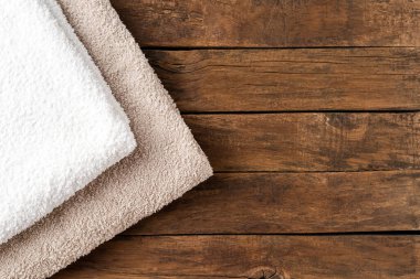 Tepeden çekilen temiz katlanmış havlular kopyalanmış ahşap masa üzerinde.