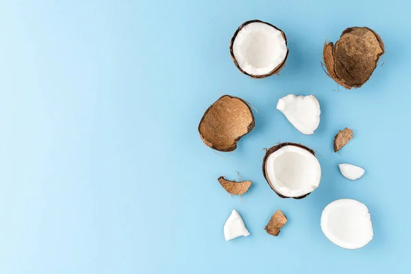 Overhead shot of coconut pieces on blue background with copyspace. Flat lay