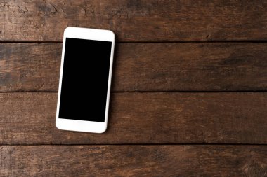 Ahşap masaüstünde boş ekranlı cep telefonu. Üst görünüm