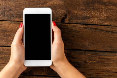 Kopyalama alanı olan akıllı telefonu tutan kadın elleri. Üst görünüm