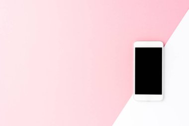 Telif uzayı ile soyut arkaplan üzerinde boş ekran olan beyaz cep telefonunun yukarıdaki görüntüsü. Düz yatıyordu