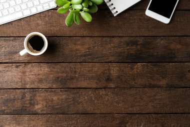 Ahşap arka planda aksesuarları ve kahve fincanı olan ofis masaüstü