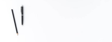 Beyaz arka planda siyah kalem ve kalem olan ofis masaüstü. Panoramik pankart