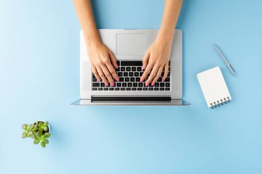 Mavi masadaki dizüstü bilgisayarda çalışan kadın eli, defter ve kalemle çekilmiş. Ofis masaüstü. Düz yatıyordu