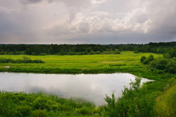 Çok bulutlu yaz gününde kırsalında küçük göl