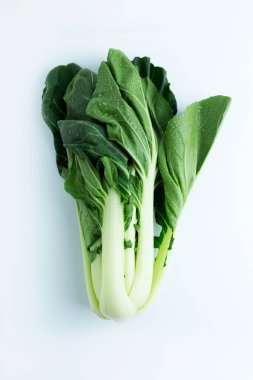 Çin lahanası Pak Choi beyaz arka planda su damlalarında. Yukarıdan bak. düşey yönelim.