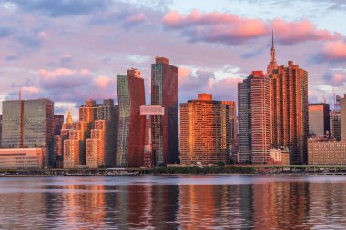 Manhattan siluetinin görünümüne Long Island City adlı gündoğumu, Queens Doğu Nehri boyunca bu alan üzerinden harika manzarası Manhattan'a bilinir.