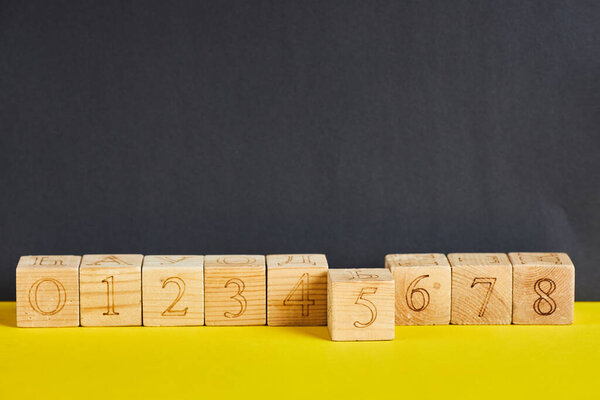 Numbers on wooden cubes in line . The number five is in forward.