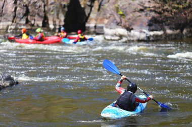 Dağ nehrinde rafting yapan bir adam.