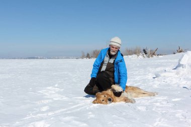 Mavi bir ceket ve bir köpek bir Labrador kışın karda bir sakallı yaşlı adam