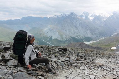 Bir sırt çantası geçişte Kara-Turek oturan adam. Akkem River Valley yakınındaki huso dağ, Altay Dağları, Rusya görünümünü